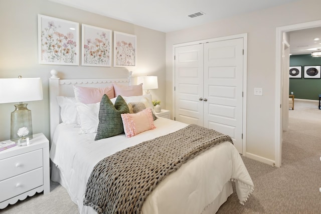 bedroom featuring a closet, light colored carpet, visible vents, and baseboards