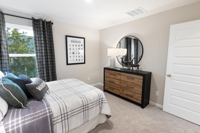 bedroom featuring baseboards, visible vents, and light colored carpet