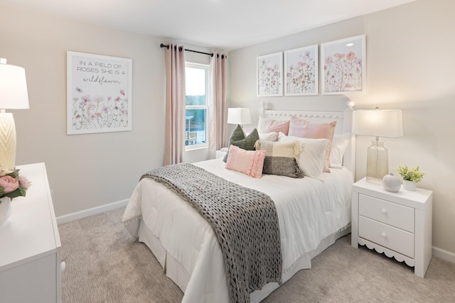 bedroom with light colored carpet and baseboards