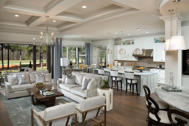 living room featuring coffered ceiling, dark wood-style floors, ornamental molding, beamed ceiling, and a notable chandelier