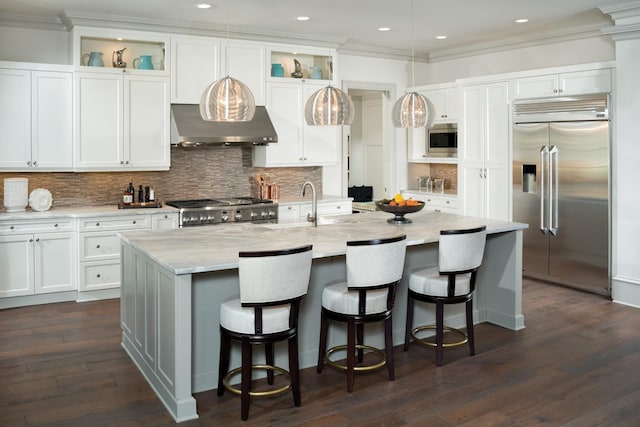 kitchen with crown molding, glass insert cabinets, white cabinets, ventilation hood, and built in appliances