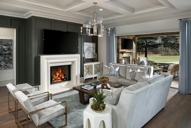 living area with crown molding, a warm lit fireplace, a notable chandelier, and a decorative wall