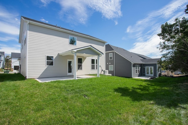 rear view of property with a patio and a lawn