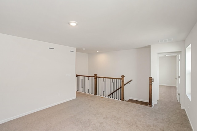 empty room with carpet, visible vents, baseboards, and recessed lighting