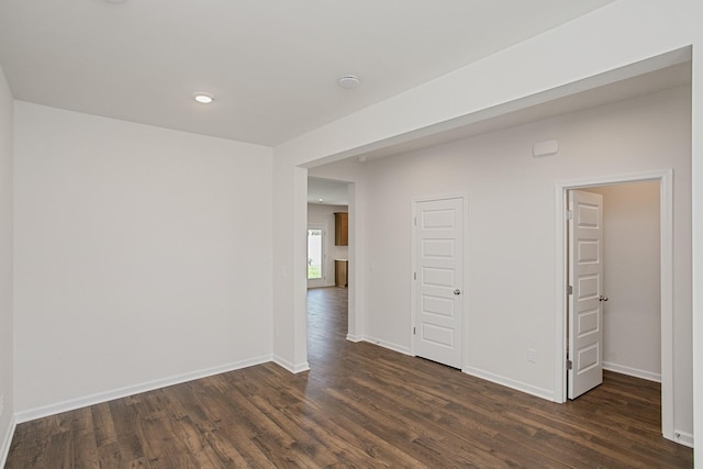 empty room with baseboards and dark wood finished floors