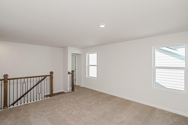 carpeted spare room featuring baseboards