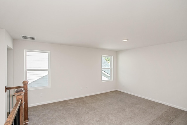 empty room featuring baseboards, visible vents, and carpet flooring