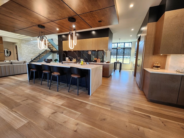 kitchen with light wood-style floors, open floor plan, light countertops, decorative backsplash, and modern cabinets