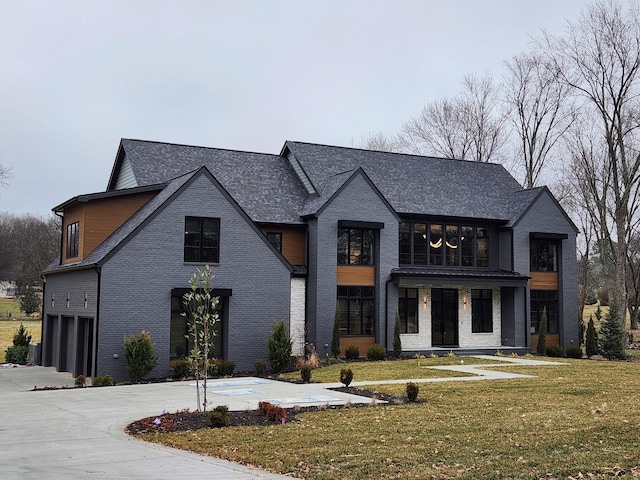 view of front of property with concrete driveway, brick siding, an attached garage, and a front lawn