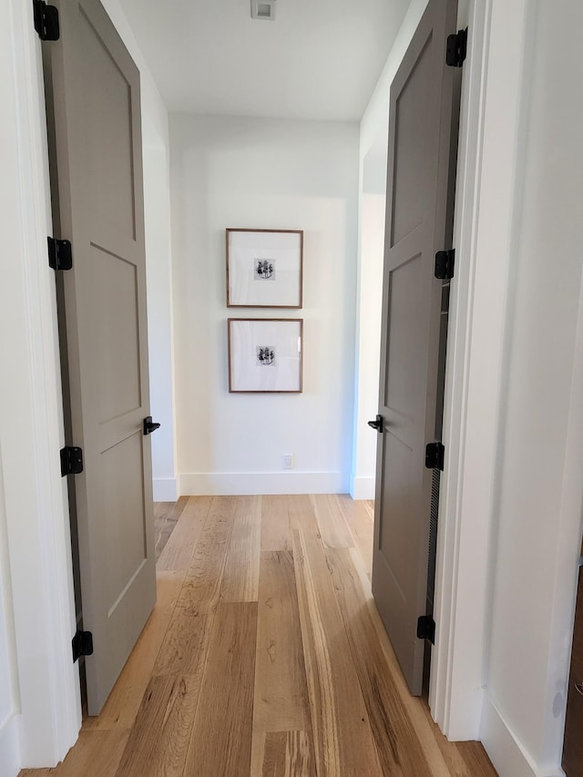 hallway with light wood finished floors and baseboards