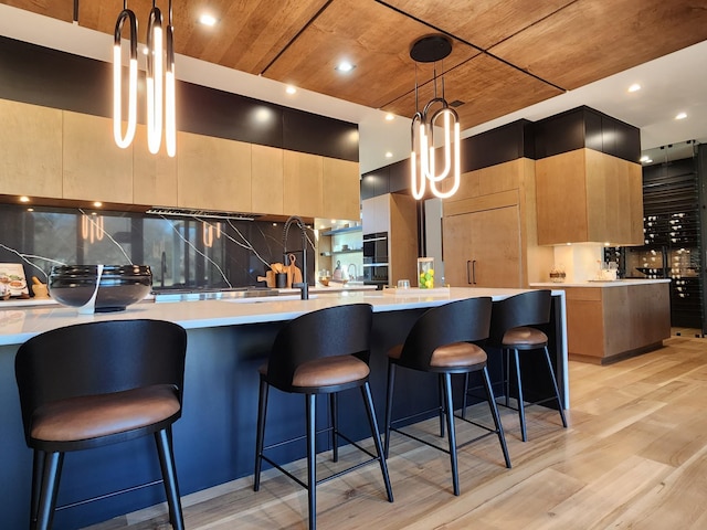 kitchen with light countertops, light wood-type flooring, modern cabinets, and decorative backsplash