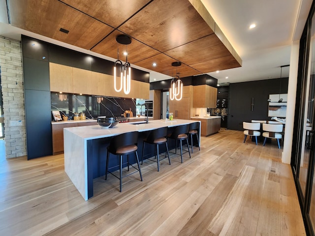 kitchen with light wood-type flooring, light countertops, a large island, and modern cabinets