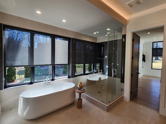 bathroom with recessed lighting, a soaking tub, visible vents, a shower stall, and tile patterned floors