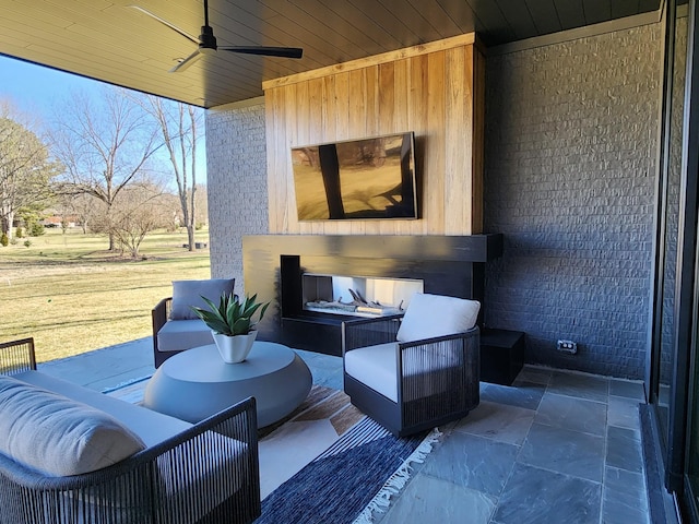 view of patio featuring an outdoor living space with a fireplace and a ceiling fan