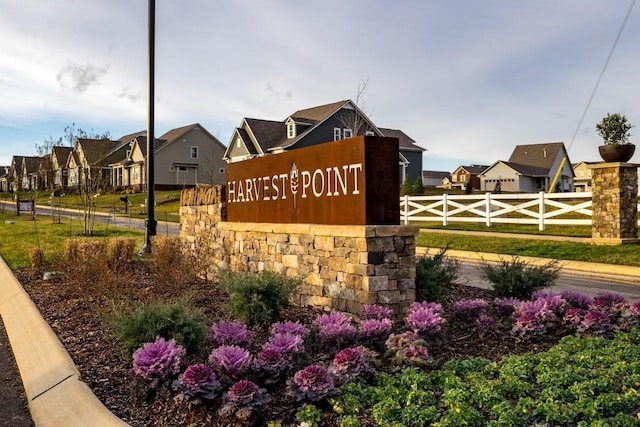 community / neighborhood sign with fence and a residential view