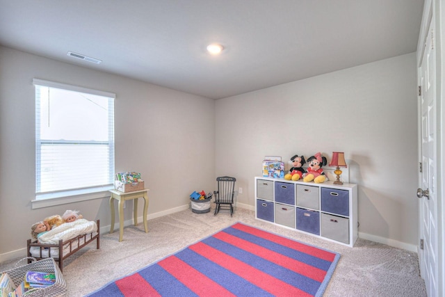 rec room with light colored carpet, visible vents, and baseboards