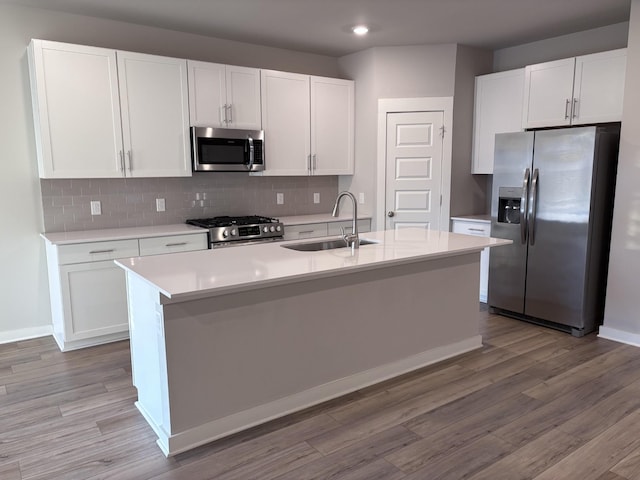 kitchen featuring a sink, stainless steel appliances, tasteful backsplash, and white cabinets