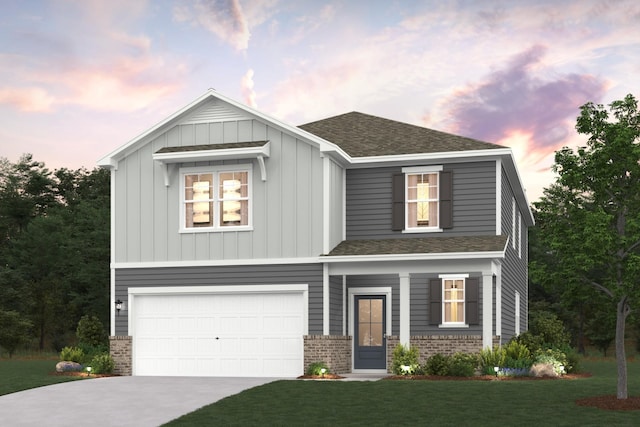 view of front of home with a garage, driveway, a yard, board and batten siding, and brick siding