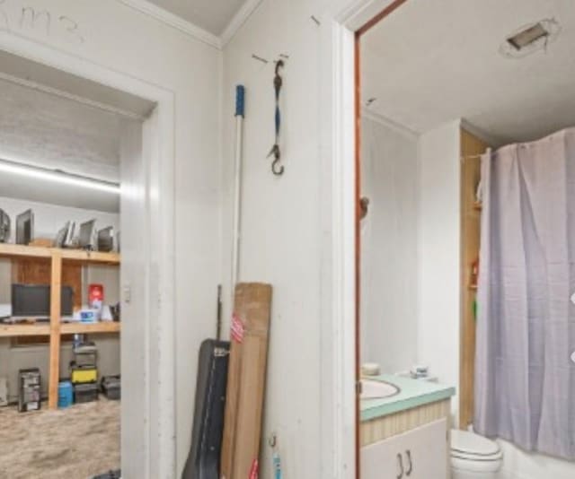 full bath featuring toilet, shower / bathtub combination with curtain, ornamental molding, and vanity