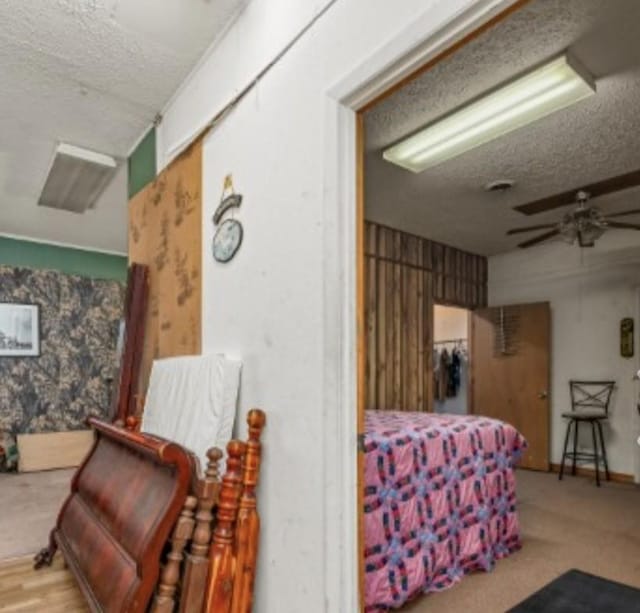 bedroom with a textured ceiling and wallpapered walls