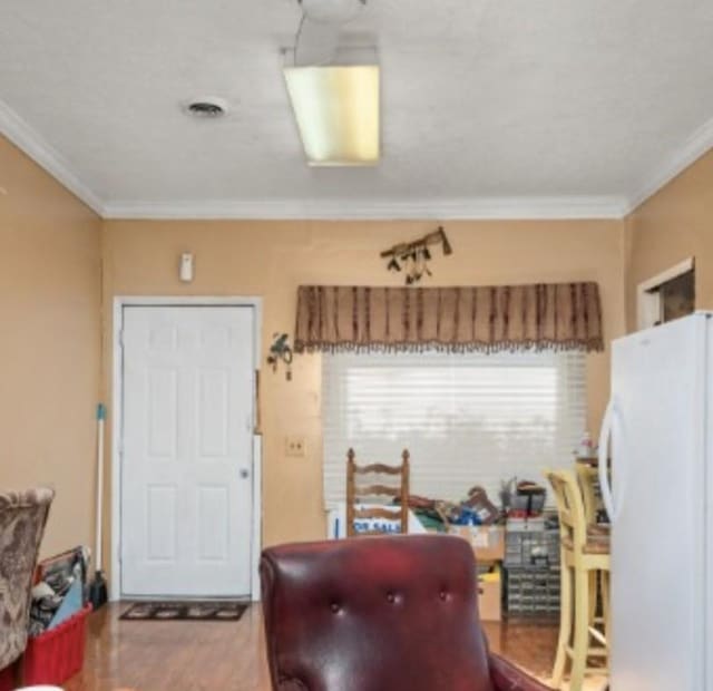 interior space with wood finished floors and crown molding