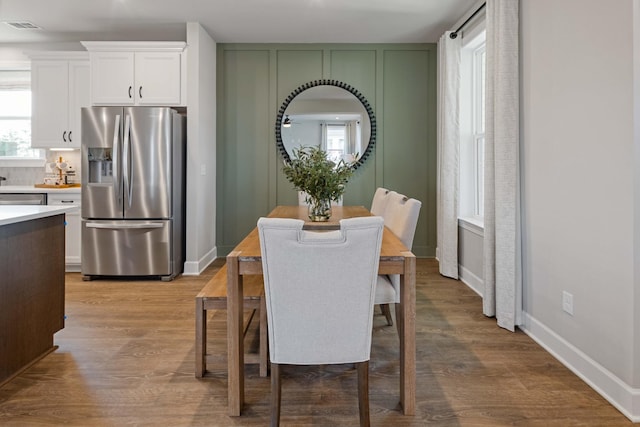 dining space featuring visible vents, baseboards, and wood finished floors