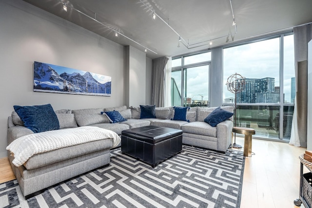 living room with wood finished floors, rail lighting, and floor to ceiling windows