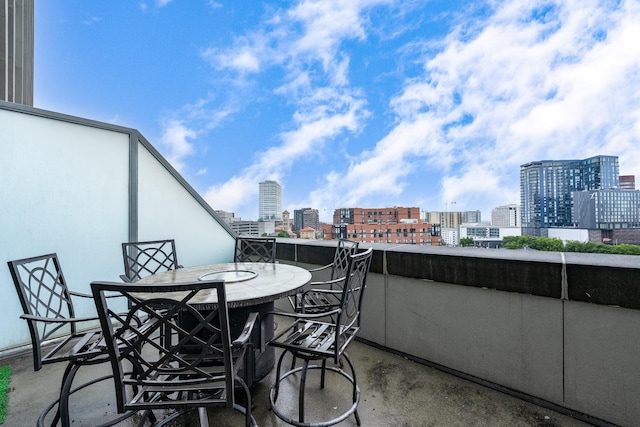 balcony featuring a view of city and outdoor dining space