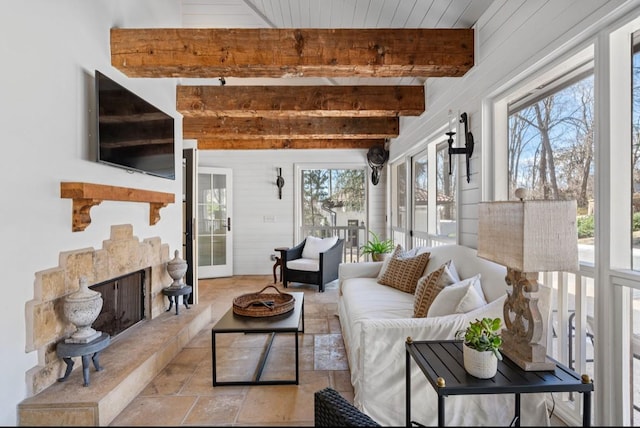 sunroom / solarium with a high end fireplace and beam ceiling