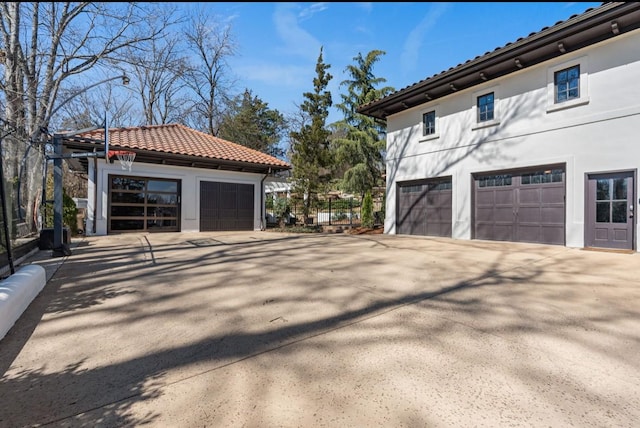 view of home's exterior featuring a garage, stucco siding, and a tiled roof