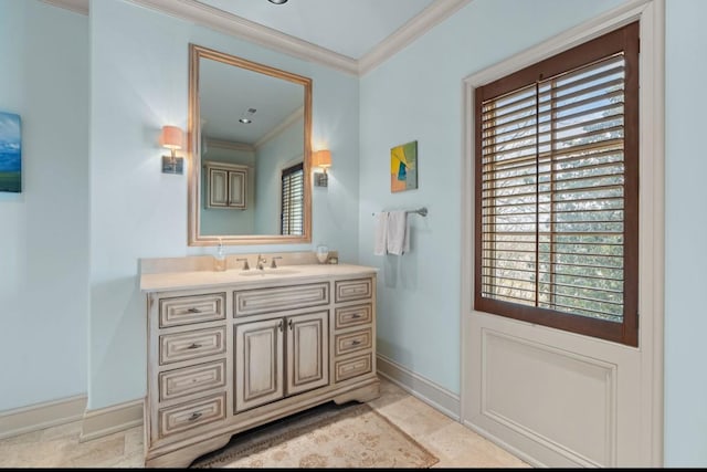 bathroom featuring baseboards, ornamental molding, and vanity