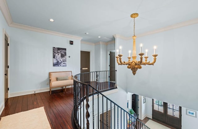 interior space featuring crown molding, wood-type flooring, an inviting chandelier, an upstairs landing, and baseboards