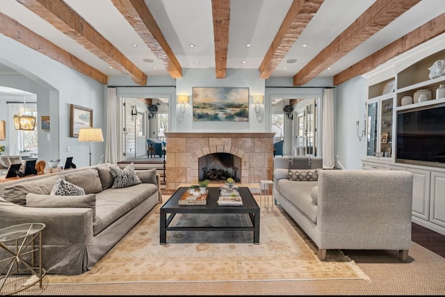 living area with recessed lighting, beam ceiling, and a fireplace