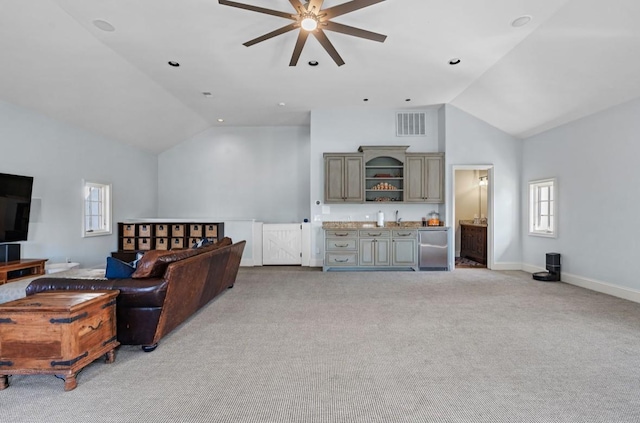 living room with light carpet, wet bar, visible vents, and a wealth of natural light