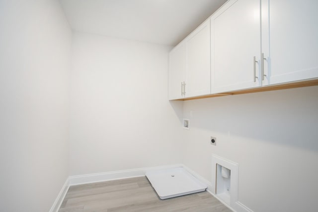 clothes washing area with cabinet space, baseboards, light wood-style flooring, hookup for an electric dryer, and washer hookup