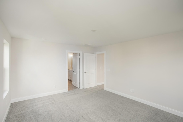 empty room with light carpet and baseboards