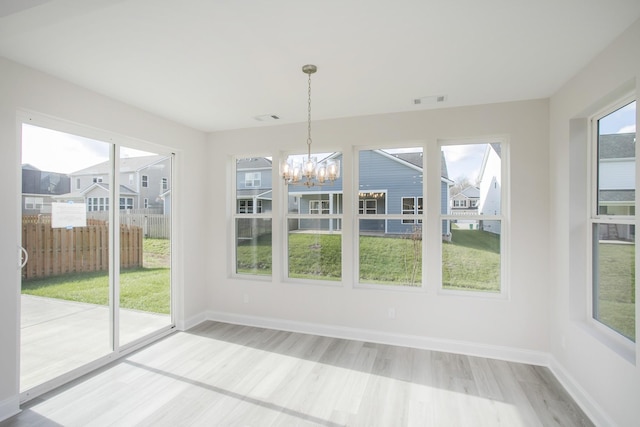 unfurnished sunroom featuring an inviting chandelier, a residential view, and visible vents