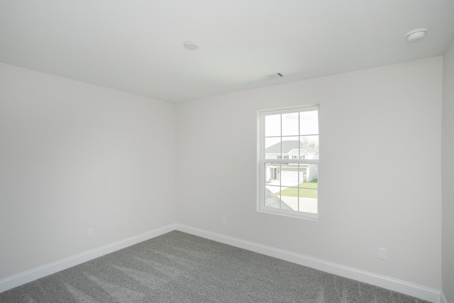 carpeted empty room with visible vents and baseboards