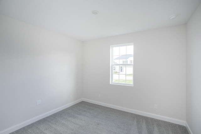 spare room with carpet and baseboards