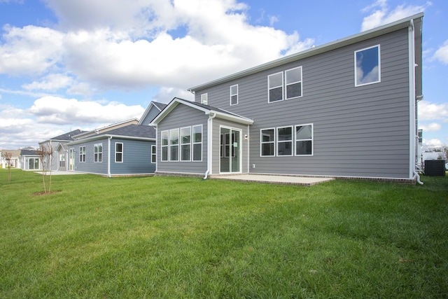 back of property with central AC unit, a patio, and a yard