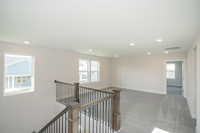 corridor featuring baseboards, visible vents, an upstairs landing, carpet floors, and recessed lighting