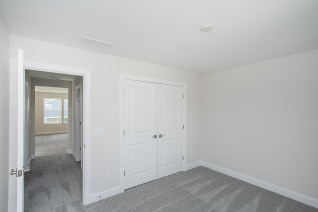 unfurnished bedroom featuring carpet floors, a closet, and baseboards