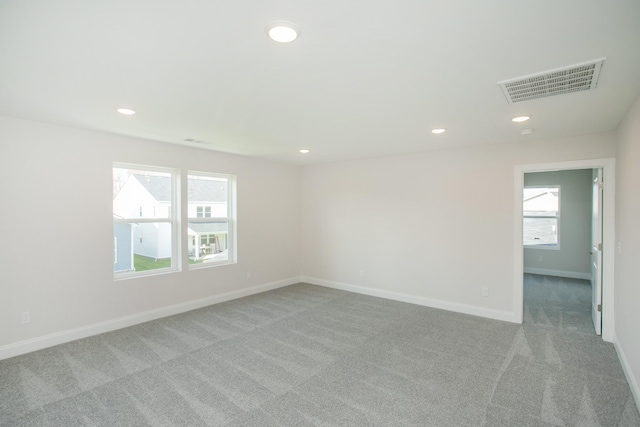 carpeted empty room with recessed lighting, a healthy amount of sunlight, and visible vents