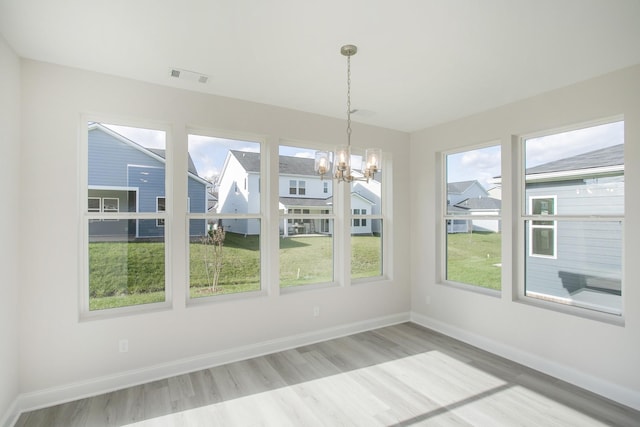 unfurnished dining area featuring light wood-style flooring, visible vents, baseboards, and a wealth of natural light