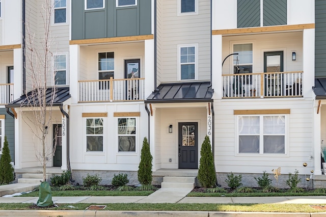 townhome / multi-family property with a standing seam roof, metal roof, and board and batten siding