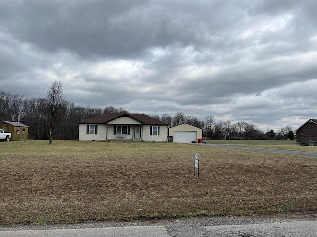 ranch-style home featuring an outbuilding, a front lawn, and a detached garage