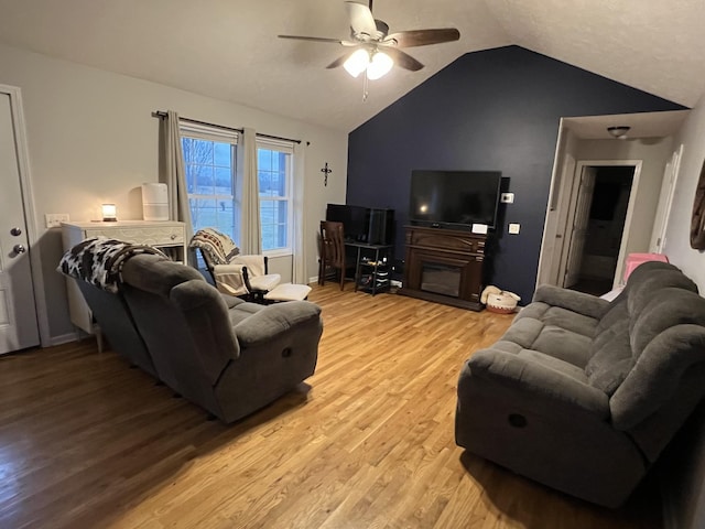 living area featuring light wood-type flooring, vaulted ceiling, and a ceiling fan