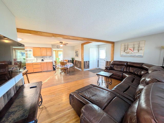 living area with light wood-type flooring and a textured ceiling