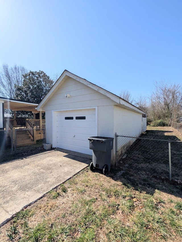 exterior space with an outdoor structure, a detached garage, and driveway