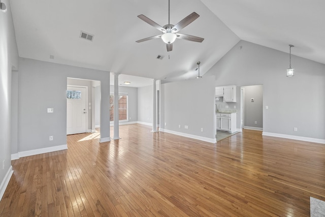 unfurnished living room featuring visible vents, baseboards, decorative columns, light wood-style floors, and a ceiling fan